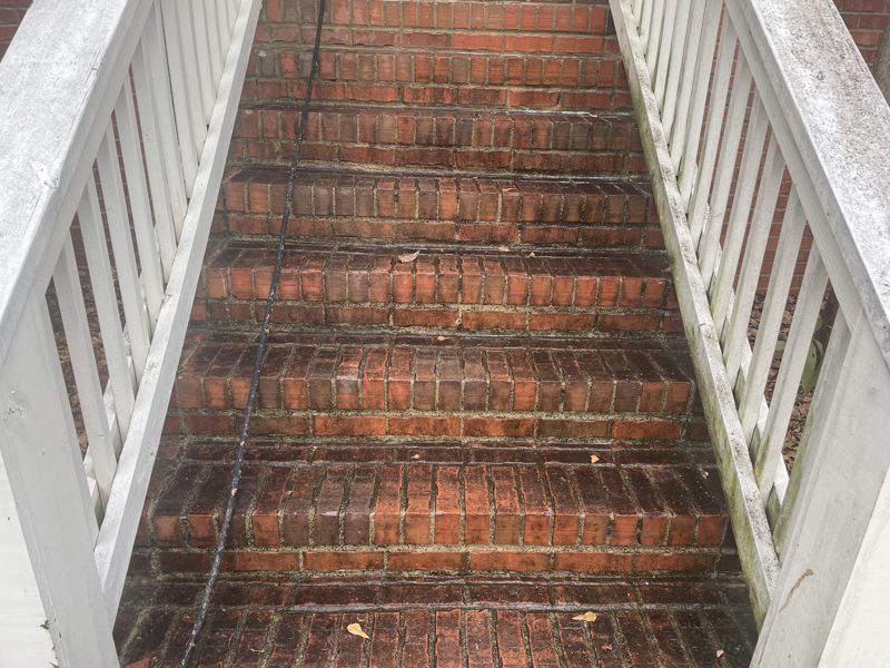 Brick stair before cleaning, heavy soiling across the treads