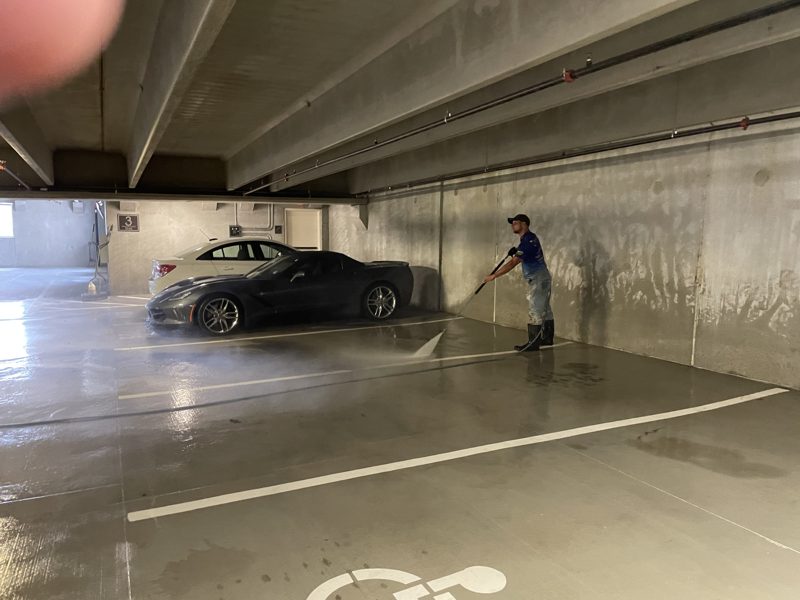 Washing a level of an occupied parking deck, vehicles still in place