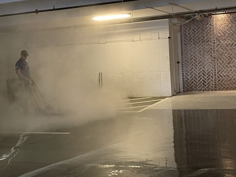 Washing a level of an occupied parking deck, vehicles still in place