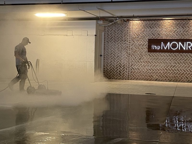 Washing a level of an occupied parking deck, vehicles still in place