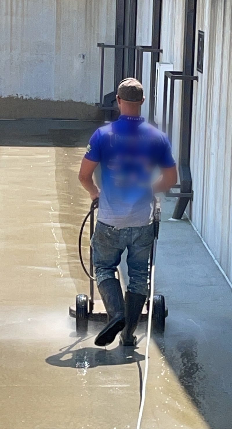Surface cleaner working a concrete elevation on a commercial site