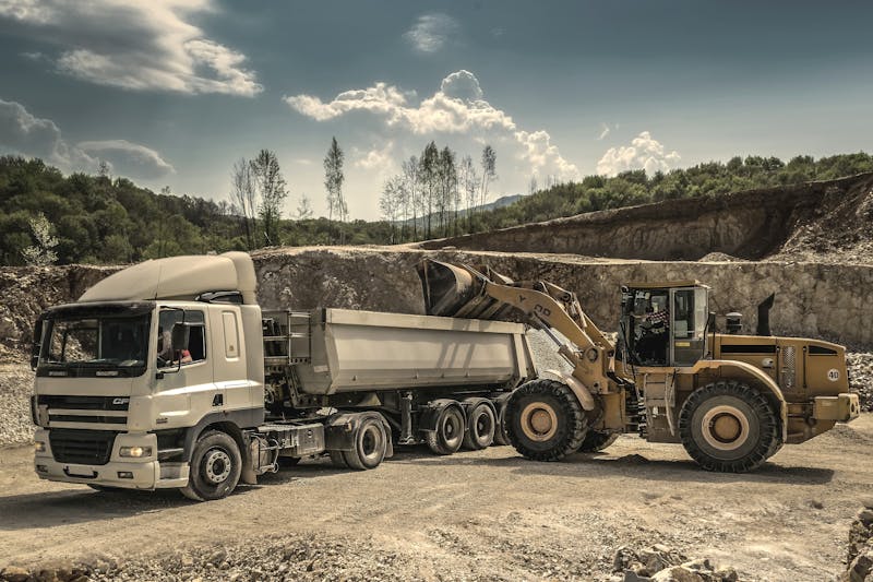 Loader filling dump truck at aggregate quarry